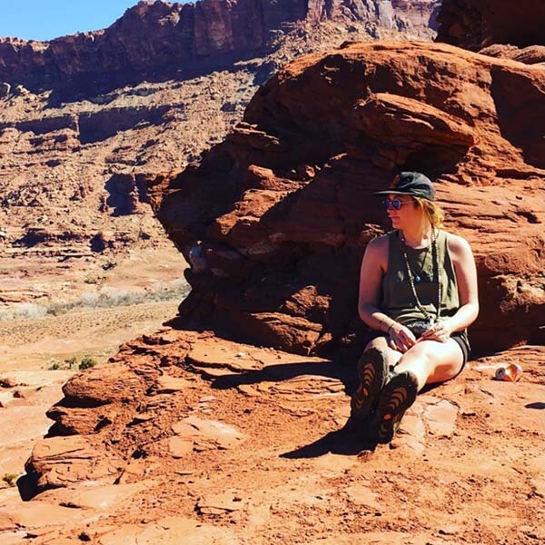 Karen sitting outside on rocks during a hike